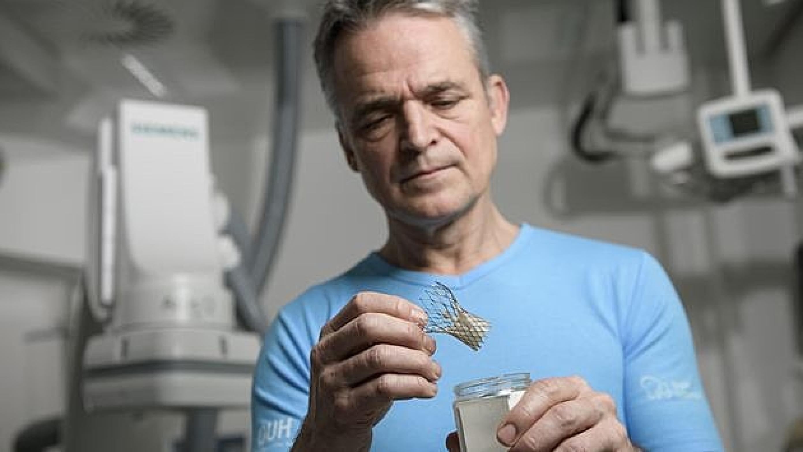 Overlæge på OUH, Anders Junker, med en kunstig hjerteklap, der kan føres via et rør gennem lysken ved forsnævring i patientens egen hjerteklap. Foto: Palle Peter Skov.