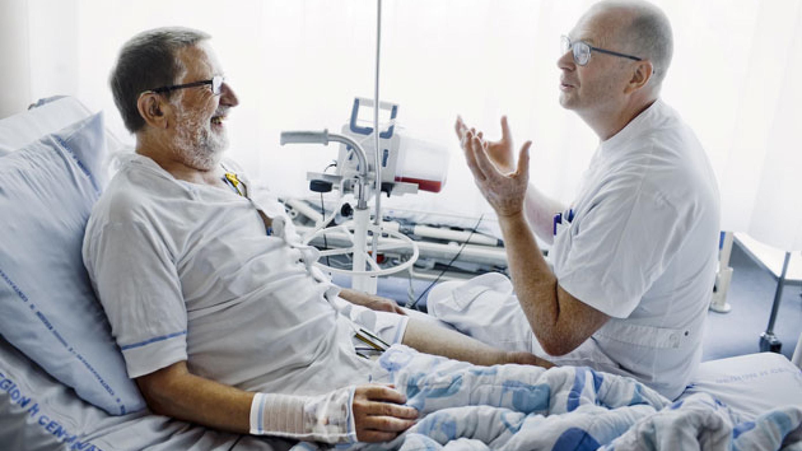 Overlæge Henrik Vad i samtale med patient. Da der kommer besked om et donorhjerte, må han slippe, hvad han har i hænderne. Foto: Claus Boesen.