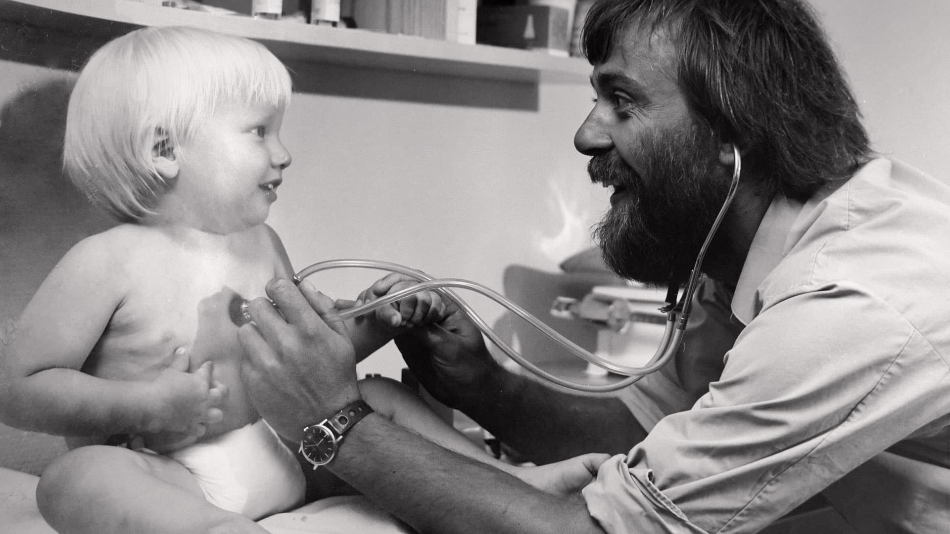 Min far kom fra Nordjylland, læste medicin i København, boede i kollektiv i Vestsjælland og købte sig derefter ind i lægehuset i Hvalsø som 32-årig i 1978. Fotograf Ole Vorre tog i 1980 en fotoserie af ham, og barnet på billedet er fotografens. Foto: Ole Vorre.