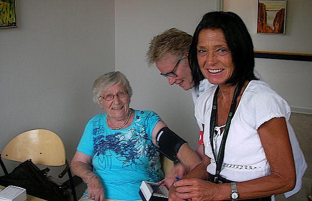 Anette Bendiksen sammen med patient og sygeplejerske i baggrunden.