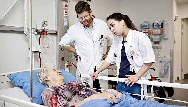 Ledende overlæge Christian Christiansen og Sükriye Corap, speciallæge på ortopædkirurgisk afdeling snakker med en patient. Foto: Astrid Dalum