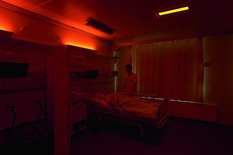 Anders Sode West tilser en patient om natten, hvor det almindelige hospitalslys er bandlyst og kun ravfarvet lys må komme ind. Foto: Allan Toft.