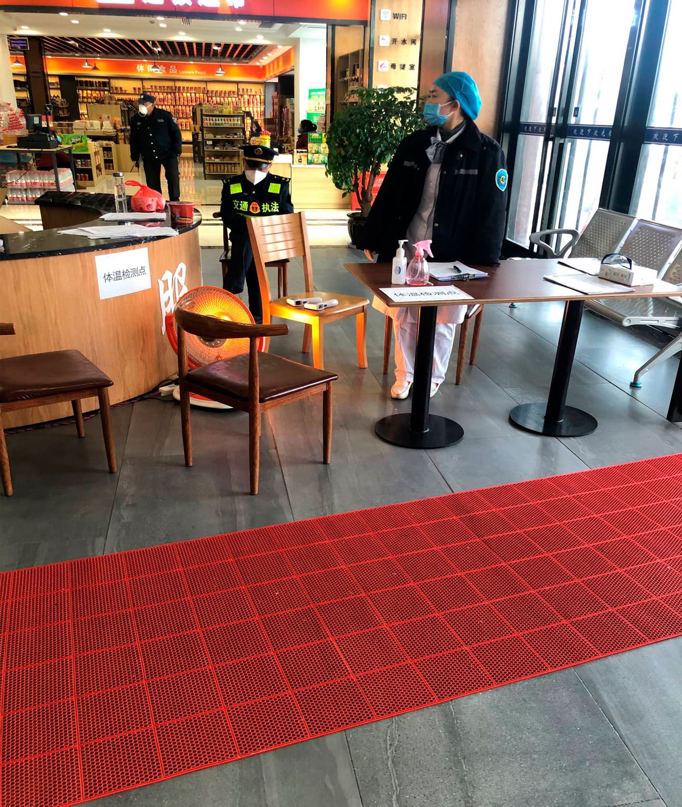 Indgangen til et motorvejscafeteria (man kan vel at mærke ikke få kaffe!). Fuld temperaturkontrol og vagter, men ingen kunder udover min kollega og mig. Læg mærke til, hvordan vagten i baggrunden bærer maske.
