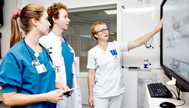 Sygeplejerske Laila Mejdal kigger på belægningstavlen med KBU-lægerne Julie Fynboe Manniche Ebert og Frederik Spangsberg Ahlers, Akutafdelingen i Viborg 2019. (Arkivfoto: Astrid Dalum)