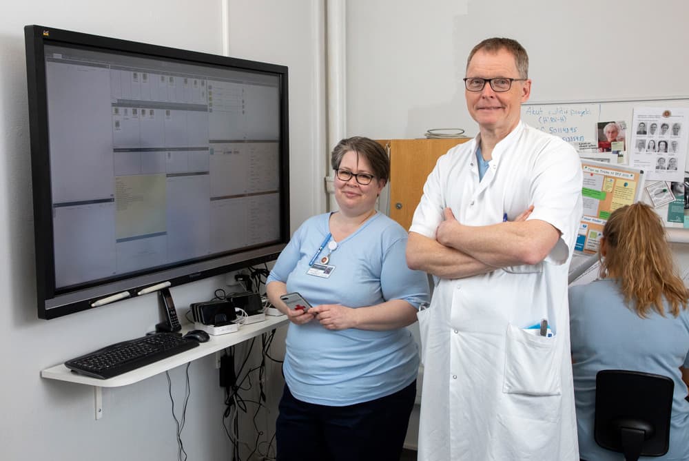 Implementeringsleder Trine Ladingkær og overlæge Jens Kjeldsen foran en af Cetrea-skærmene. Før levede systemet et lidt slumrende liv, men bedre indhold og øget tilgængelighed har gjort det til nyttigt værktøj, der giver logistisk overblik over patienter og personale. Foto: Heidi Lundsgaard