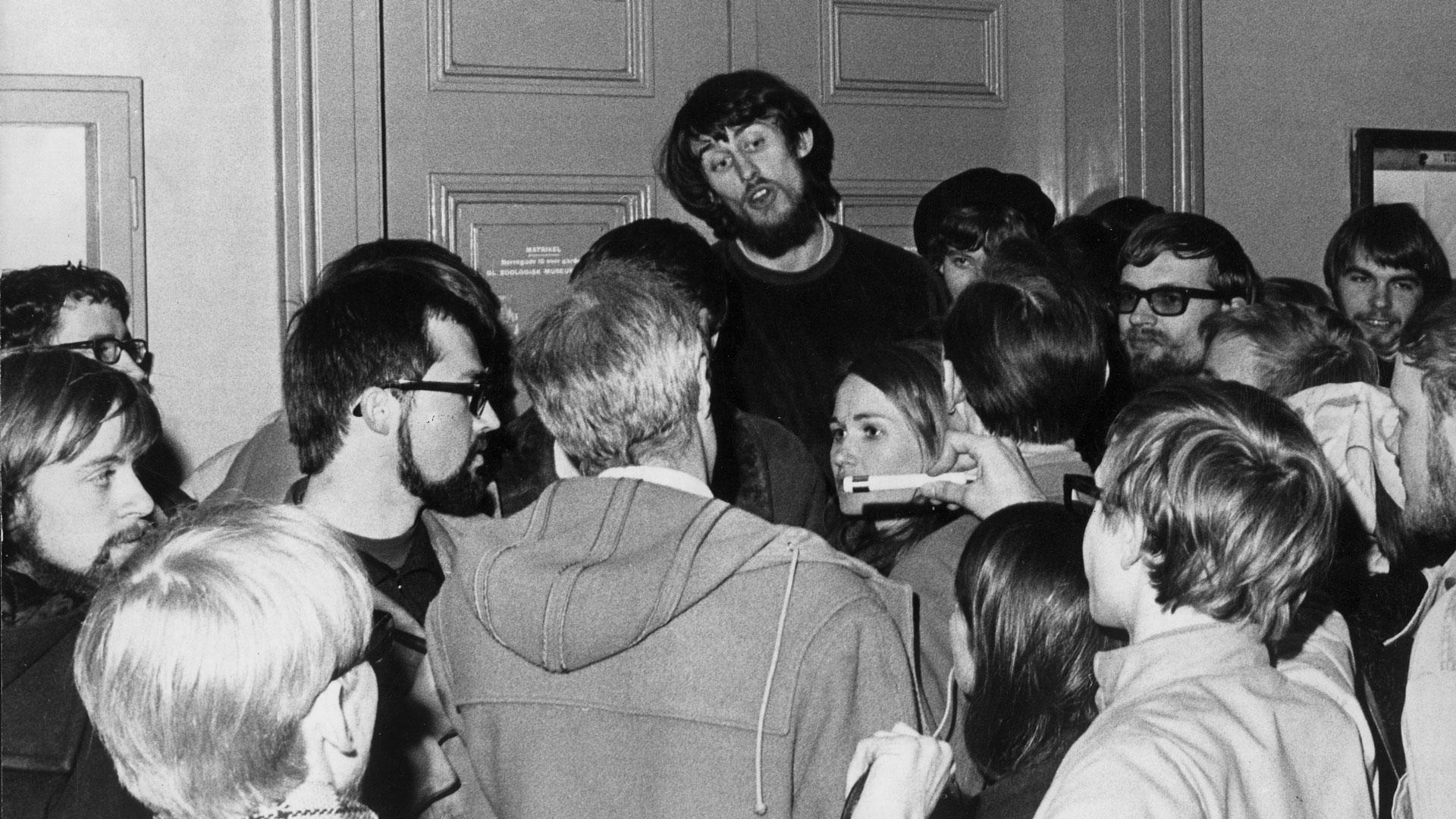 I 1969 forhindrede de medicinstuderende professorerne i at få adgang til lokalet. Rektor Mogens Fog (med ryggen til) blev vred. Min far ses helt ude i venstre hjørne med mørkt hår og fuldskæg. Foto: Ritzau/Scanpix