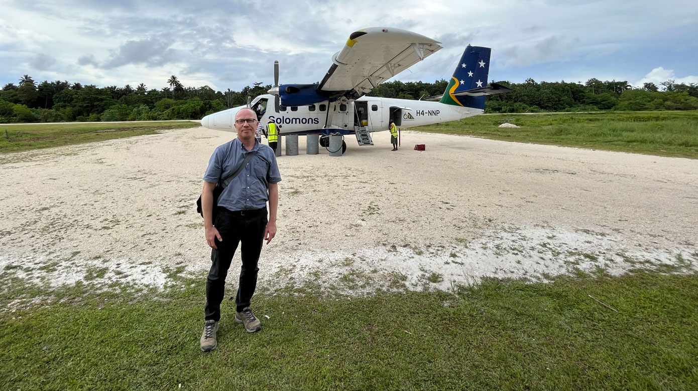Lasse Vestergaard foran det lille propelfly, der er forbindelsen til Salomonøernes hovedstad Honiara. (Foto: Privat/Lasse Vestergaard)