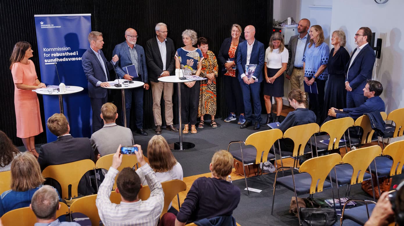 Søren Brostrøm var formand for Robusthedskommissionen og selvom han har forladt sin stilling som direktør for Sundhedsstyrelsen og nu arbejder i Geneve, var han hjemme til et pressemøde for at præsentere og overrække rapporten til Indenrigs- og Sundhedsminister Sophie Løhde. De fleste af kommissionens medlemmer står til højre på billedet. (Foto: Liselotte Sabroe/Ritzau Scanpix)