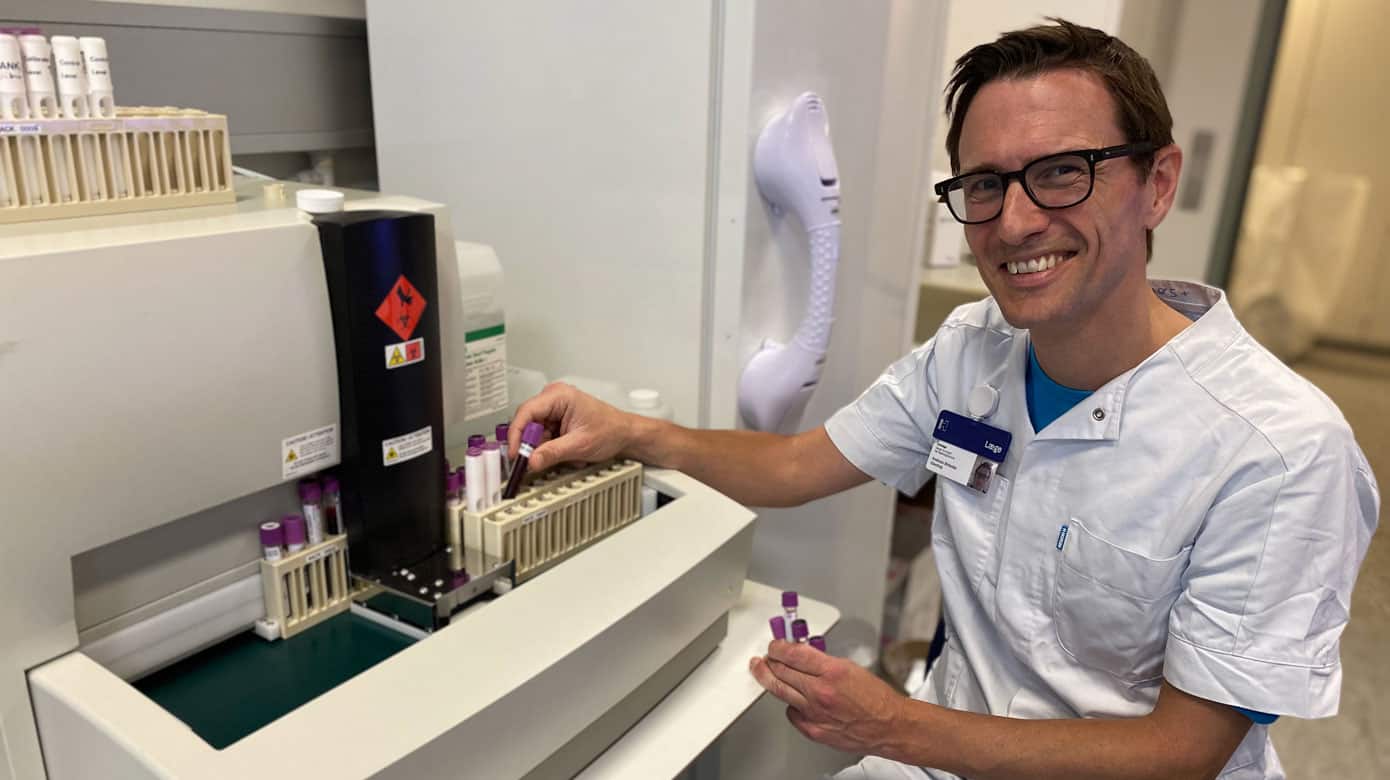 Overlæge, klinisk lektor og forskningsansvarlig på Dansk Center for Røde Blodceller, Rigshospitalet, Andreas Glenthøj foran en HPLC-maskine, som anvendes til at diagnosticere patienter med hæmoglobinsygdomme og monitorere effekten af deres behandling. Foto: Rigshospitalet