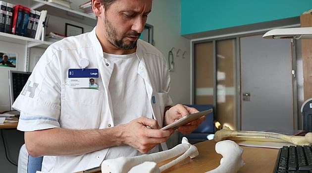 Ulrik Kähler forbereder en operation med et interaktivt anatomi atlas og kan føle anatomien med 3D printede knogler. Foto: Alexander Tange