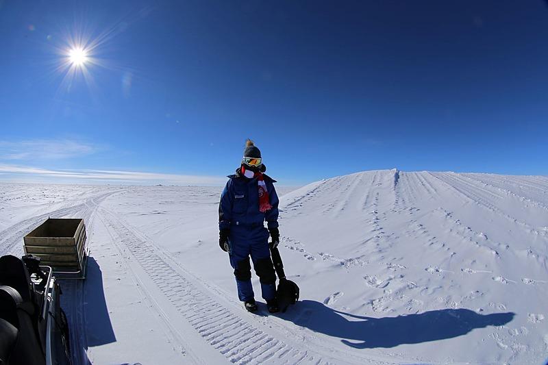 Læge Nadja Albertsen på Antarktis. I horisonten anes basen, hvor hun  skal mtilbringe et år. Privat foto.