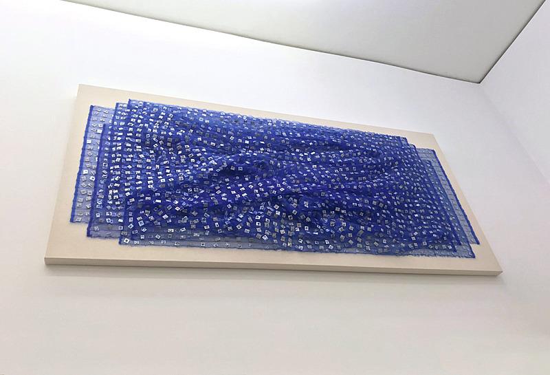 "Wave", et tørklæde i den dybblå farve, som tekstilkunster Susie Freeman har valgt til at illustrere sin egen depression, dekoreret med den medicin, der kurerede hende.