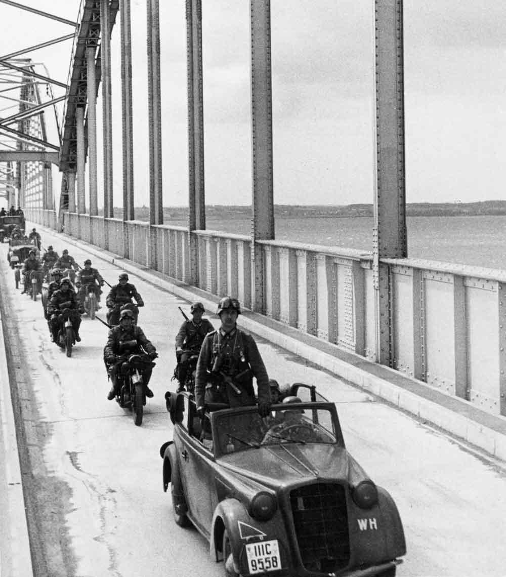 Vidner forklarede, at den tyske invasion fik Olaf Halvorsen til at bryde med nazistpartiet. Tyske invasionstropper krydser Storstrømsbroen, 9. april 1940. (Foto: Scanpix Danmark)