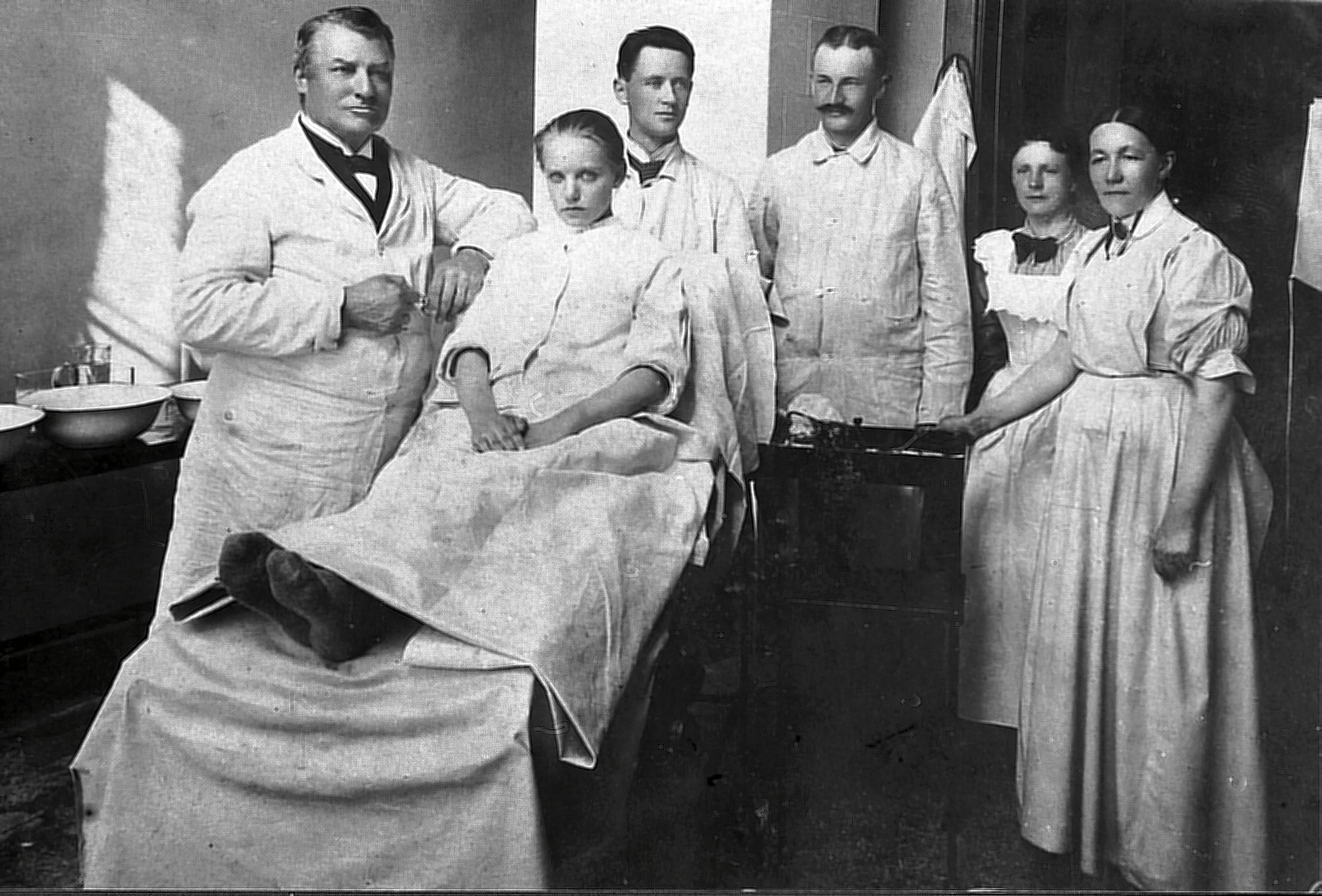 En ung pige gøres klar til operation. P.W. Heiberg ses længst til venstre. Længst til højre ses hans oversygeplejerske gennem mange år, frøken Olsen Nørskov (Viborg Museum).