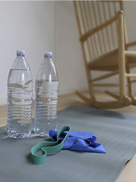 Hjemmetræning kan udføres med billige og lettilgængelige redskaber, såsom fyldte vandflasker og træningselastikker.