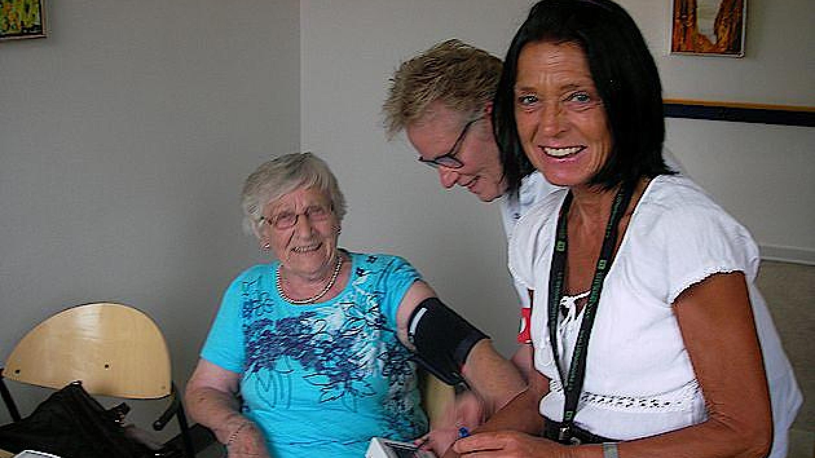 Anette Bendiksen sammen med patient og sygeplejerske i baggrunden.