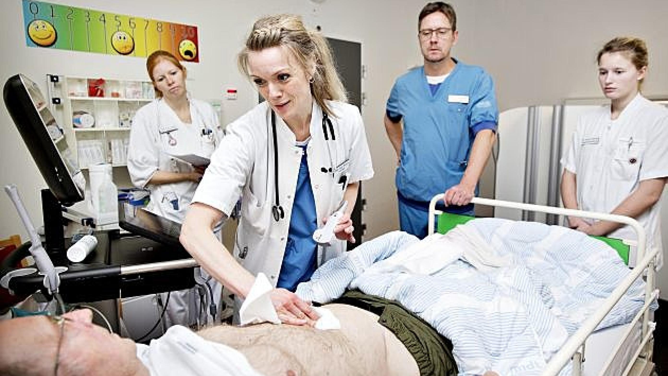 Overlæge Mille B. Morberg undersøger en patient. Ledende overlæge Larry Kristiansen og to sygeplejersker ser på. Foto: Astrid Dalum