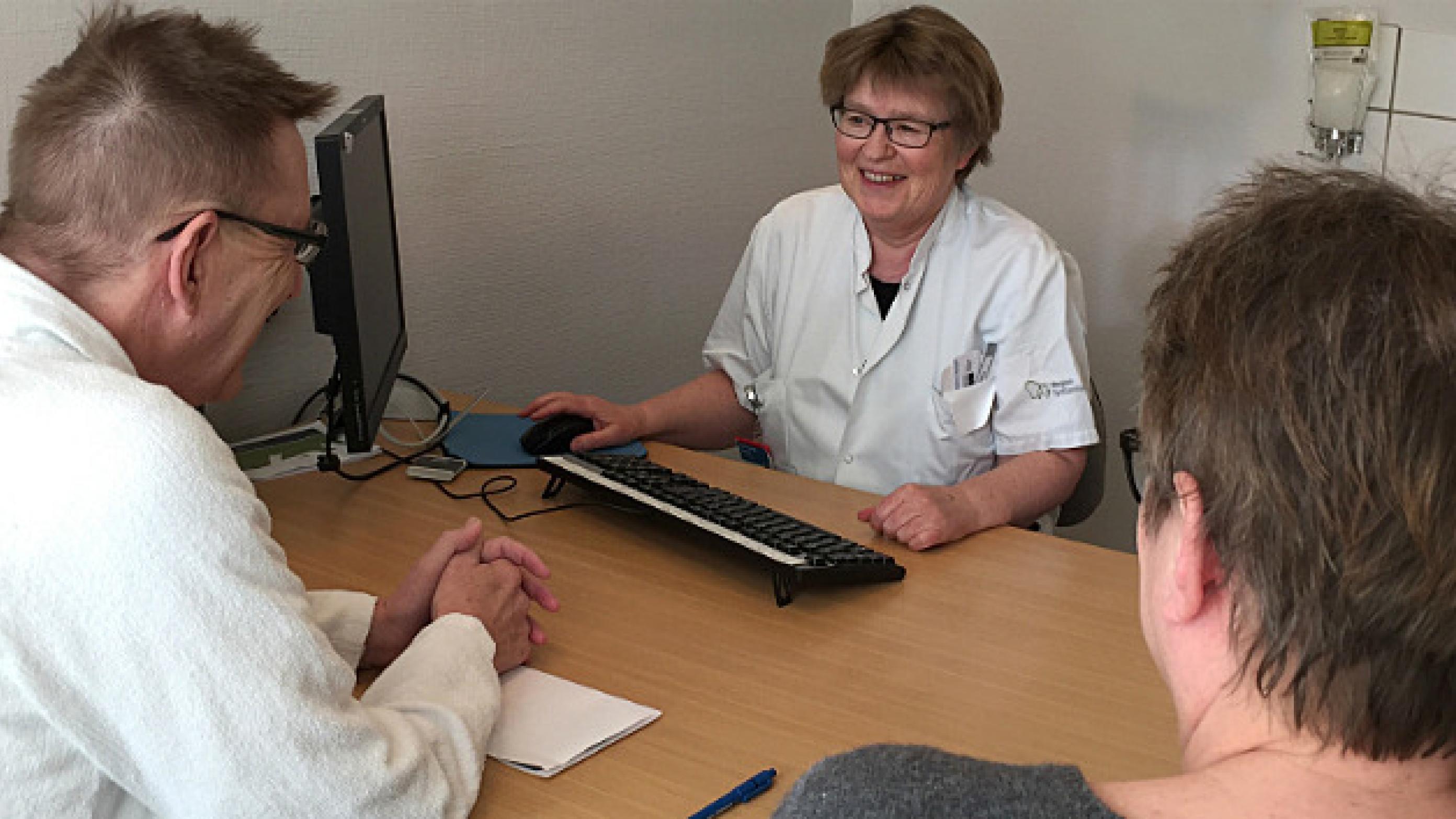 Overlæge Bente Sørensen under konsultation med patient og pårørende. 