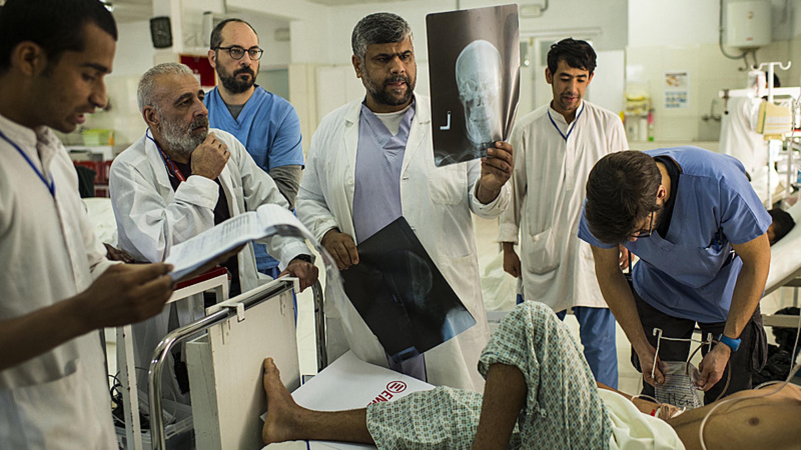 Seniortraumekirurg Dr. Ibrahim Khushal med røntgenbillederne sammen med kollegaerne på hospitalet i Lashkar Gah i Afghanistan. Foto: Andrew Quilty
