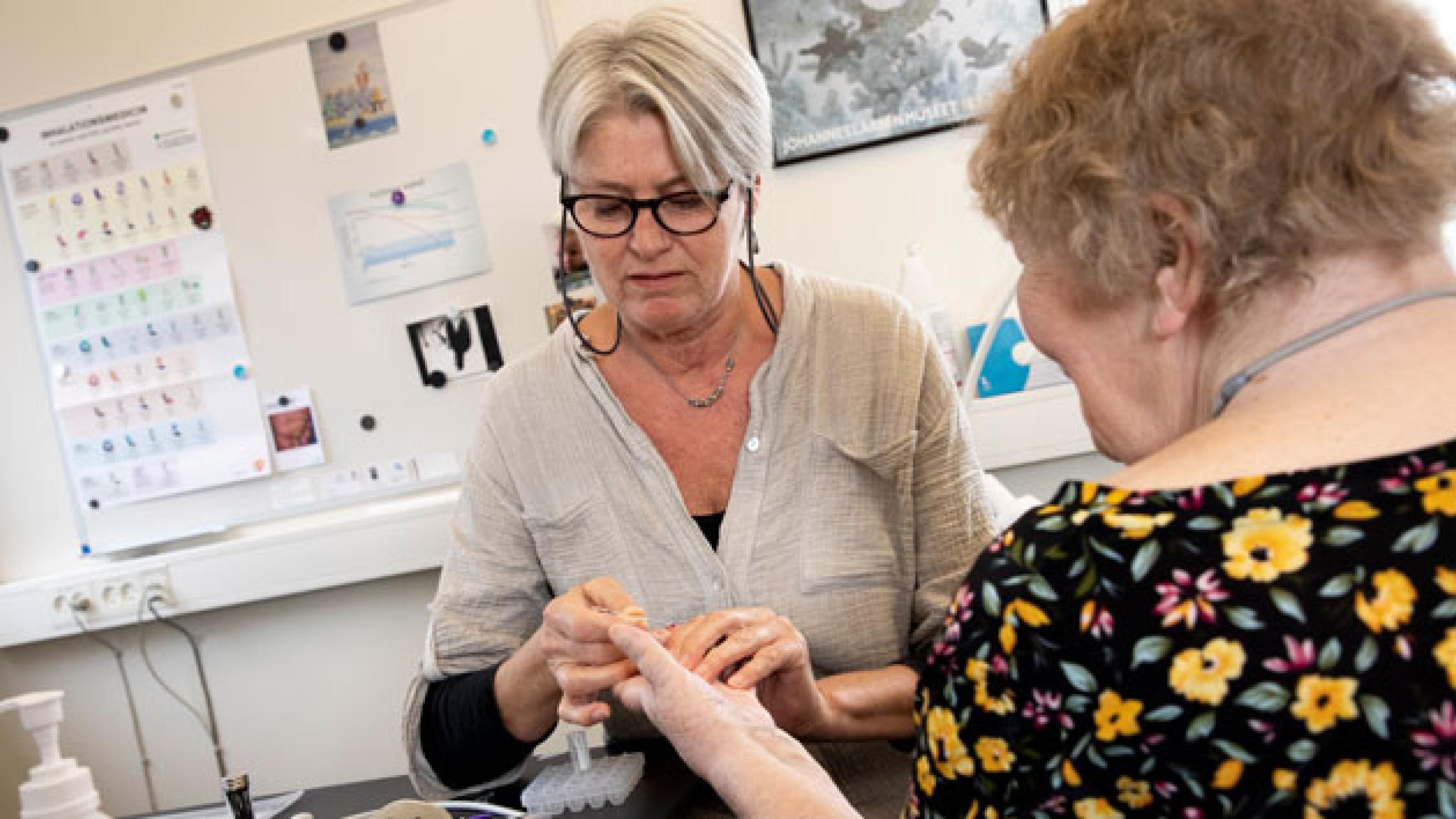 Lisbeth Johannesson har siden 2002 været ansat som sygeplejerske i almen praksis i Rudkøbing. Hun er den, der har kendt klinikkens patienter længst. Grethe er en af de patienter, som Lisbeth kører selvstændigt patientforløb med. I dag er Grethe til årskontrol – og får også tjekket sit infektionstal. Foto: Heidi Lundsgaard 